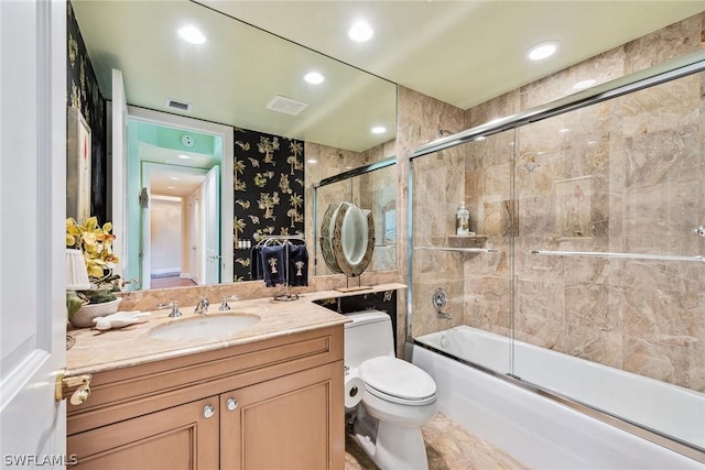 full bathroom with vanity, toilet, and enclosed tub / shower combo