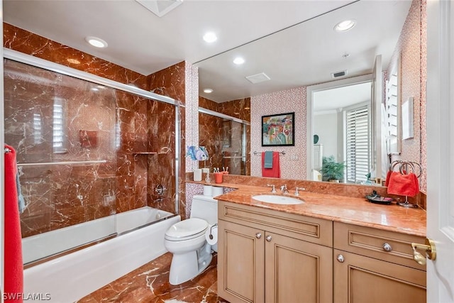 full bathroom featuring vanity, toilet, and bath / shower combo with glass door