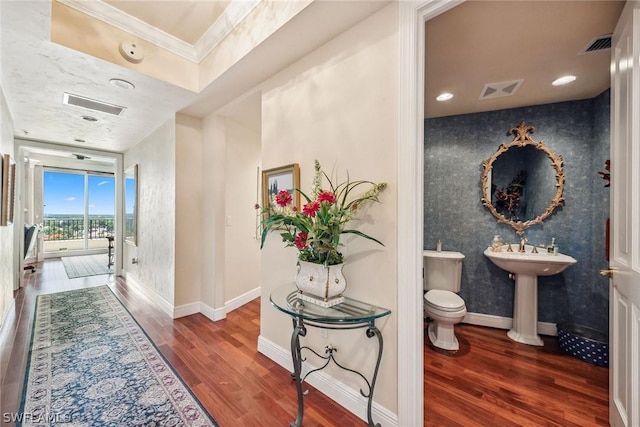 corridor with crown molding and dark wood-type flooring