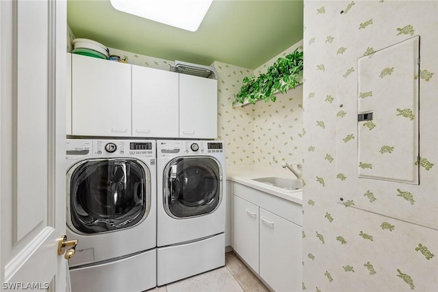 washroom featuring cabinets, light tile patterned floors, sink, and washing machine and clothes dryer