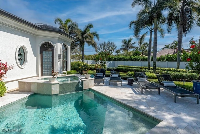 view of pool featuring fence, a patio, and an in ground hot tub