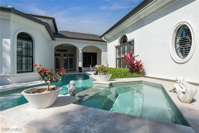 outdoor pool with french doors and a patio