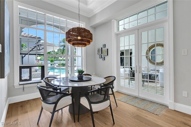 dining room with light wood-style flooring, ornamental molding, and french doors