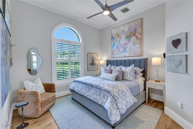 bedroom with ornamental molding, baseboards, and wood finished floors