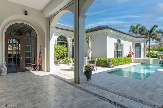 view of pool featuring french doors, a patio area, and a pool with connected hot tub