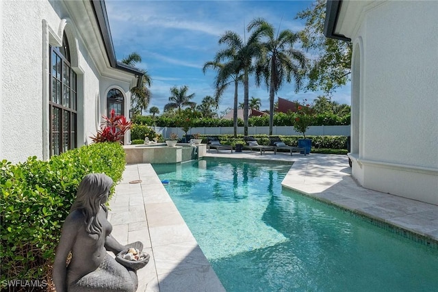 view of pool with a pool with connected hot tub, a patio area, and a fenced backyard