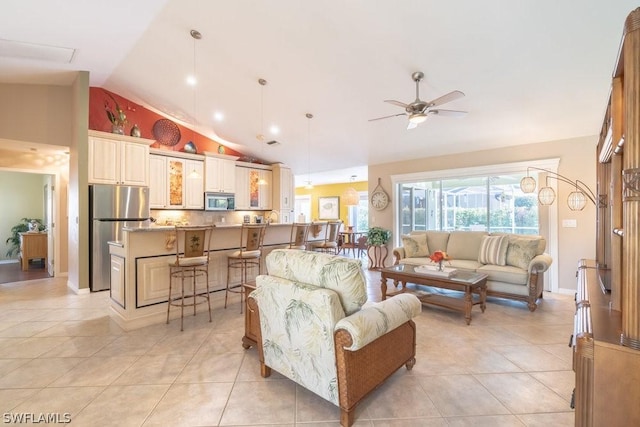 tiled living room with ceiling fan and vaulted ceiling