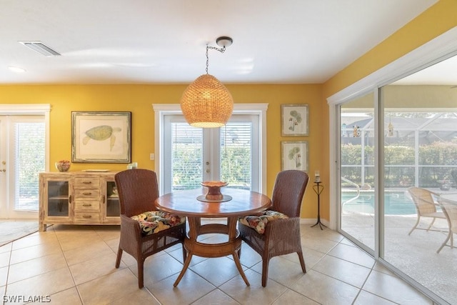 dining area featuring light tile patterned floors and french doors