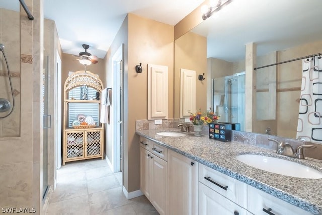 bathroom with tile patterned flooring, ceiling fan, a shower with shower door, and vanity