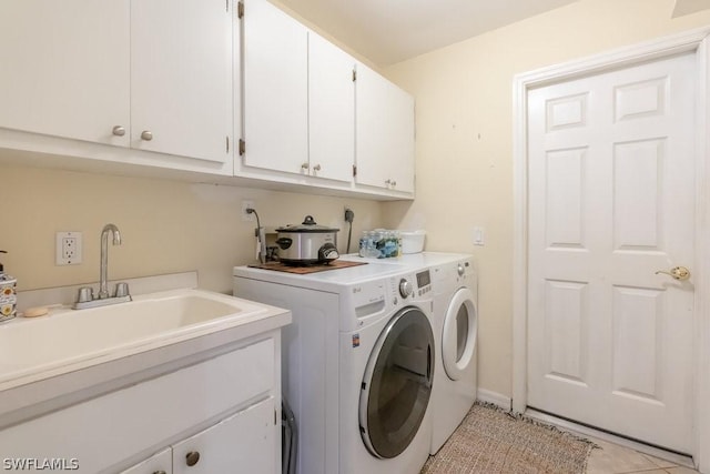 washroom with cabinets, light tile patterned floors, sink, and washing machine and clothes dryer