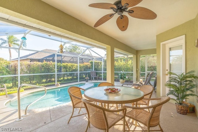 view of pool featuring ceiling fan, a patio, and glass enclosure