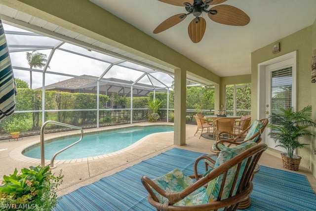 view of swimming pool featuring ceiling fan, a patio, and glass enclosure