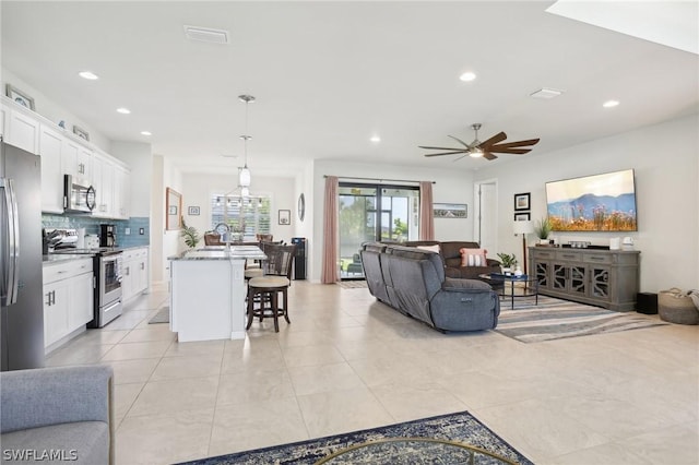 tiled living room with ceiling fan