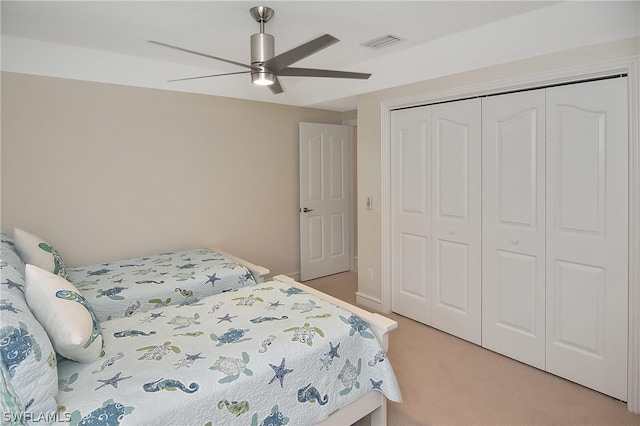 carpeted bedroom with ceiling fan and a closet