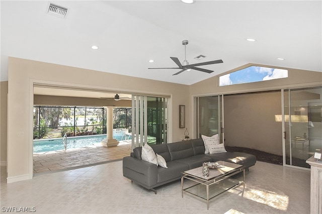 living room featuring ceiling fan, light tile patterned floors, and vaulted ceiling