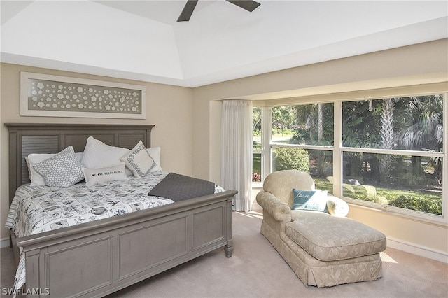 carpeted bedroom with a raised ceiling and ceiling fan