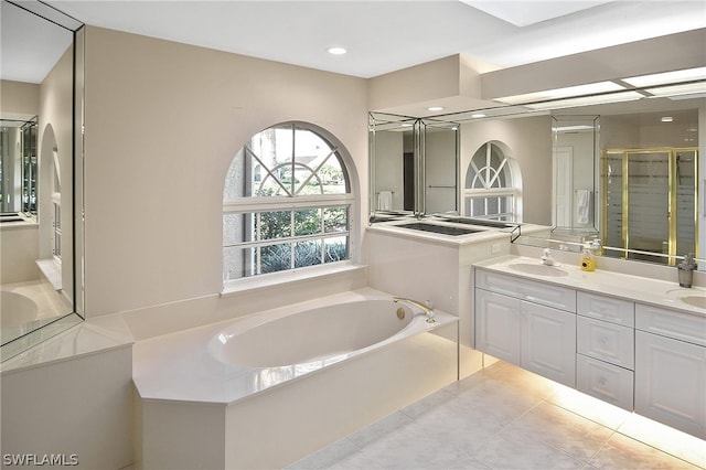 bathroom with tile patterned floors, vanity, and shower with separate bathtub