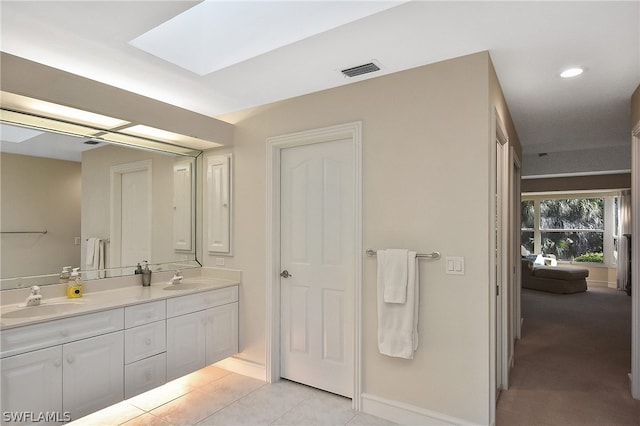 bathroom featuring a skylight, tile patterned flooring, and vanity