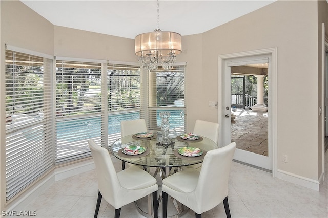 tiled dining room with a chandelier