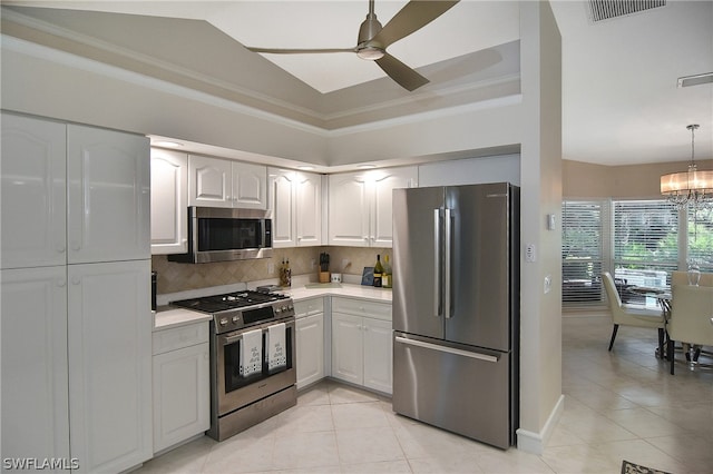 kitchen with white cabinetry, backsplash, light tile patterned floors, ceiling fan with notable chandelier, and appliances with stainless steel finishes