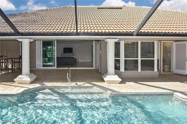 rear view of property with a fenced in pool