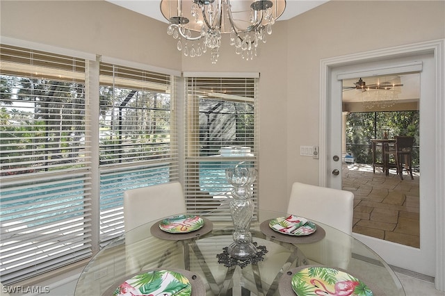 dining room with ceiling fan with notable chandelier and tile patterned floors