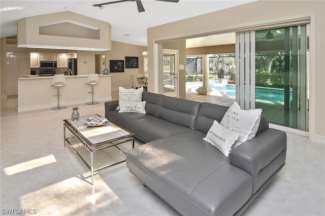 tiled living room with ceiling fan and lofted ceiling