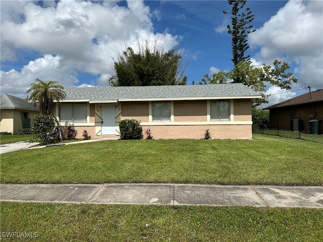 ranch-style home with central air condition unit and a front yard