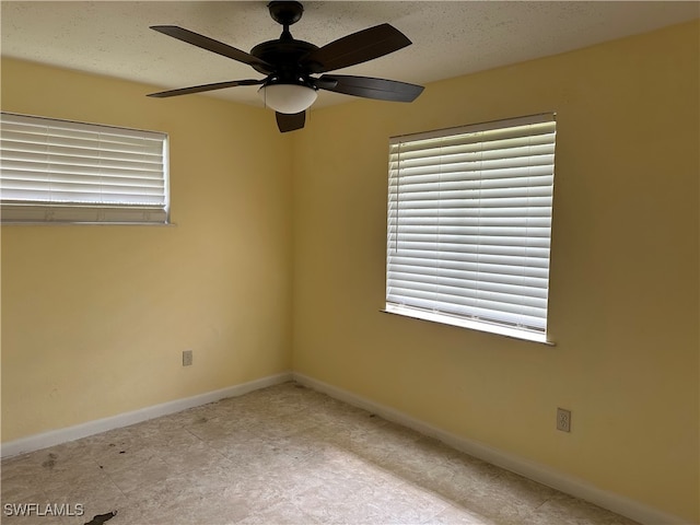 empty room featuring ceiling fan and a textured ceiling