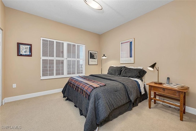 bedroom with baseboards, a textured ceiling, and light colored carpet