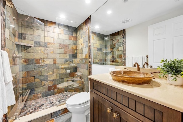 bathroom featuring recessed lighting, visible vents, toilet, vanity, and a walk in shower