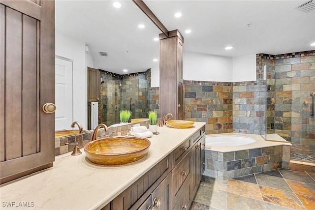 bathroom featuring a shower stall, stone tile floors, visible vents, and a sink