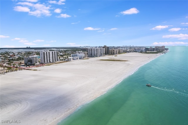 drone / aerial view with a water view and a beach view