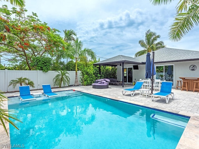 view of pool with ceiling fan, a patio, and exterior bar