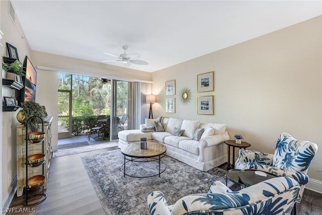 living area featuring ceiling fan, wood finished floors, visible vents, and baseboards