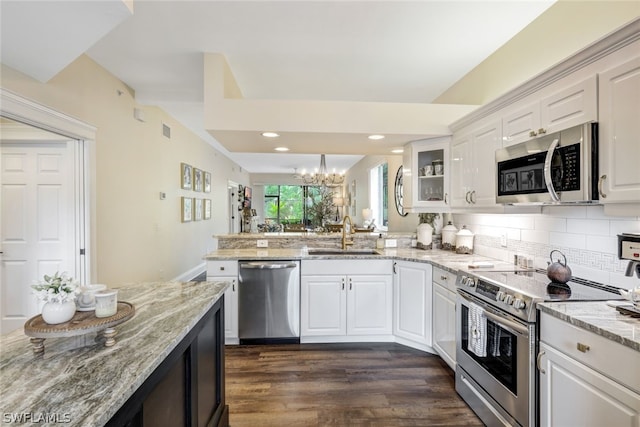 kitchen featuring white cabinets, light stone counters, glass insert cabinets, stainless steel appliances, and a sink