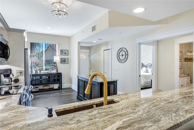 kitchen with dark wood-style floors, visible vents, appliances with stainless steel finishes, a sink, and light stone countertops