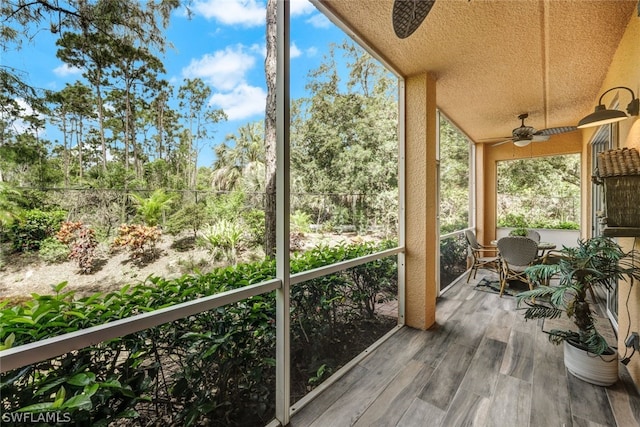 unfurnished sunroom featuring ceiling fan