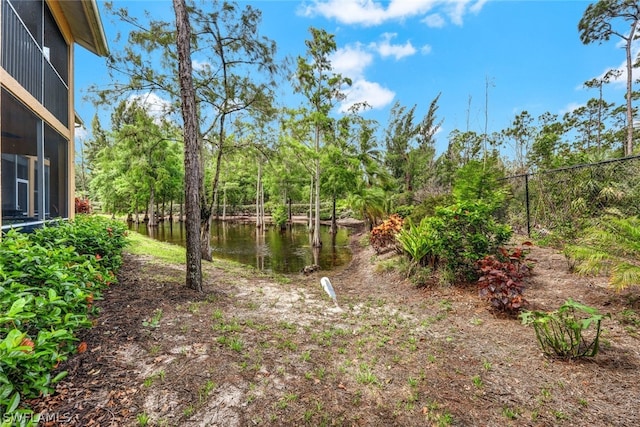 view of yard featuring a water view and fence