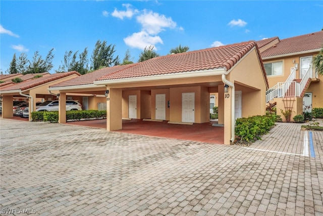 townhome / multi-family property with a tile roof and stucco siding