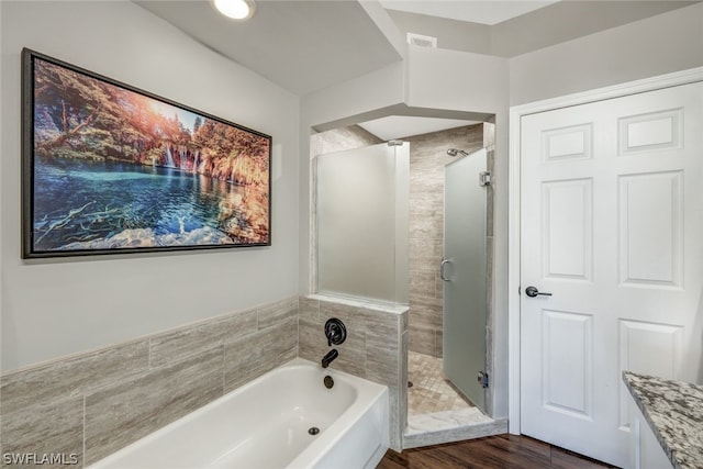 full bath with visible vents, a garden tub, a shower stall, and wood finished floors