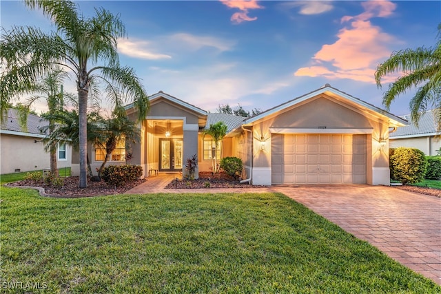 ranch-style house featuring a lawn and a garage