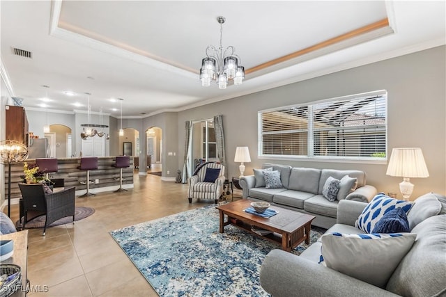 tiled living room with a raised ceiling, a chandelier, and crown molding