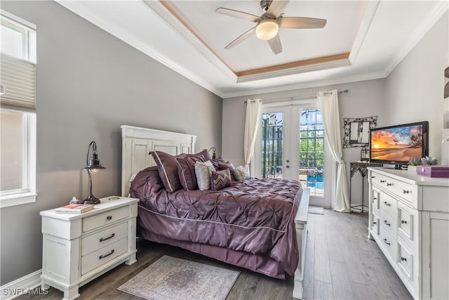 bedroom featuring french doors, crown molding, access to exterior, a tray ceiling, and dark hardwood / wood-style floors