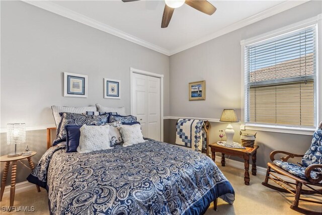 bedroom featuring ceiling fan, ornamental molding, light carpet, and a closet