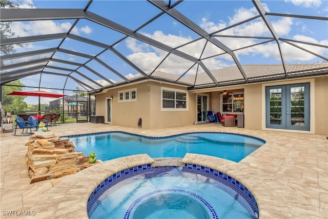 view of swimming pool featuring an in ground hot tub, glass enclosure, ceiling fan, and a patio area