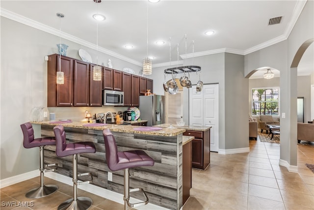 kitchen featuring kitchen peninsula, light tile patterned flooring, hanging light fixtures, and appliances with stainless steel finishes