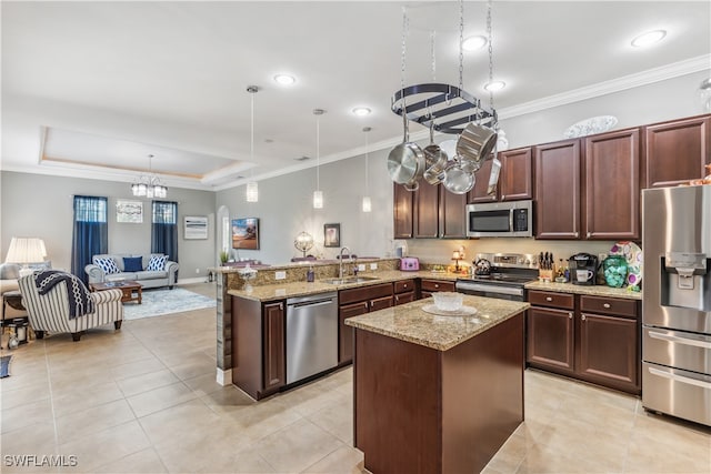 kitchen featuring kitchen peninsula, sink, pendant lighting, and appliances with stainless steel finishes