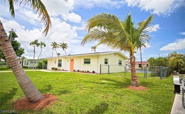 view of front of house featuring stucco siding, a gate, fence, and a front yard