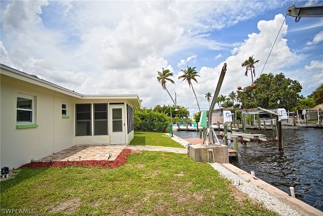 view of yard with a water view, boat lift, and a boat dock